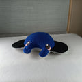 Blue plush toy with black ears on a white surface